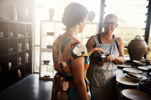 Two women in kitchenware shop payment transaction